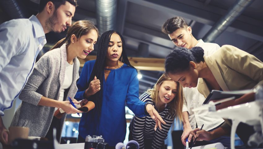 People in workplace around a table for Enovation