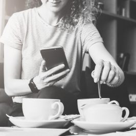 femme avec un smartphone et une tasse de café